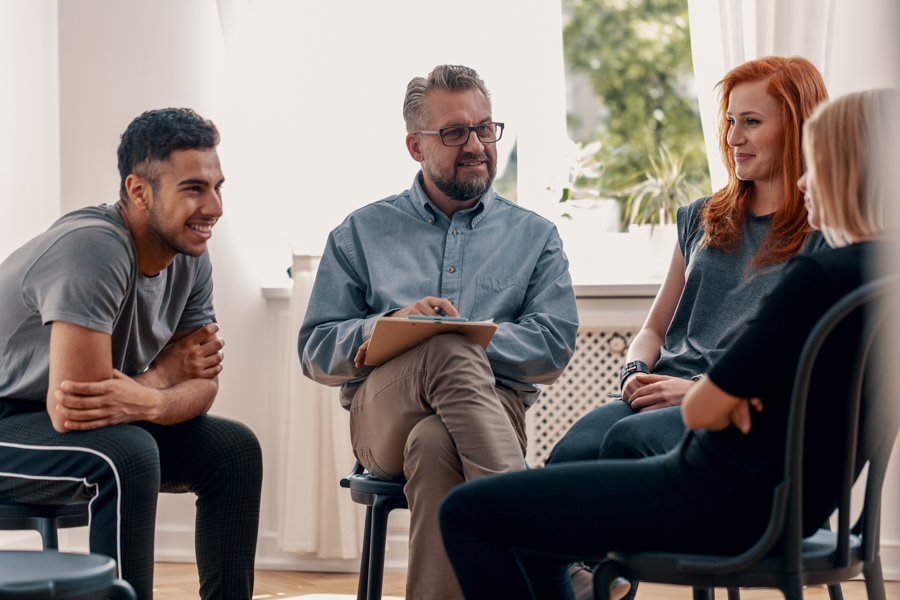Smiling spanish man talking with friends during meeting for teen