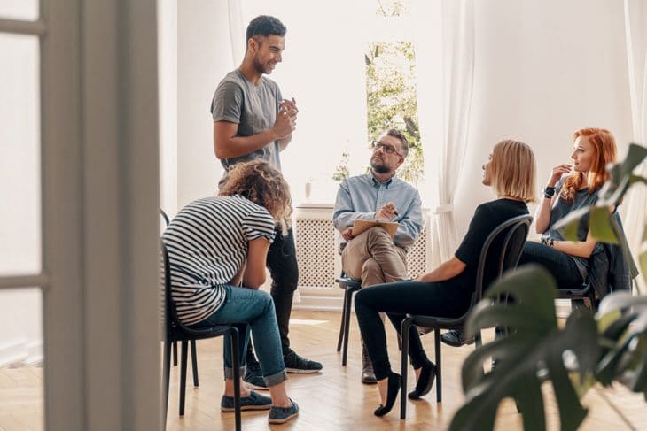 A group is having therapy with a licensed therapist